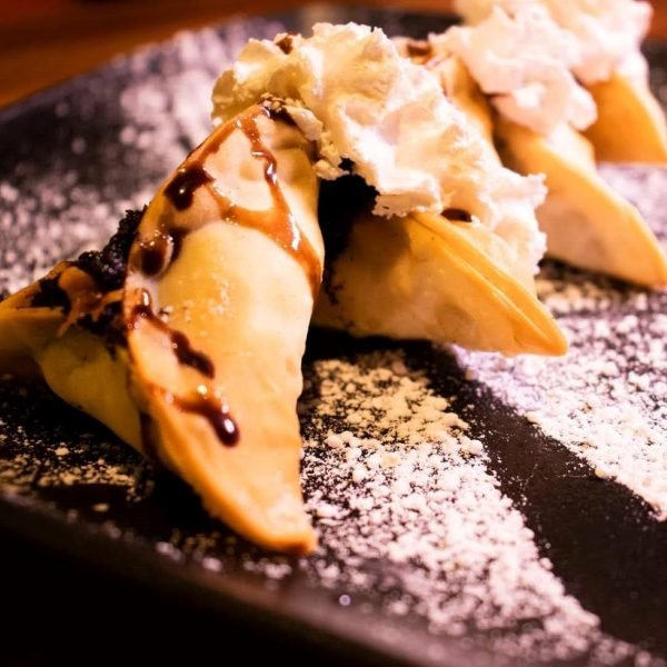 Crispy Fried Chocolate Momo topped with whipped cream and drizzle